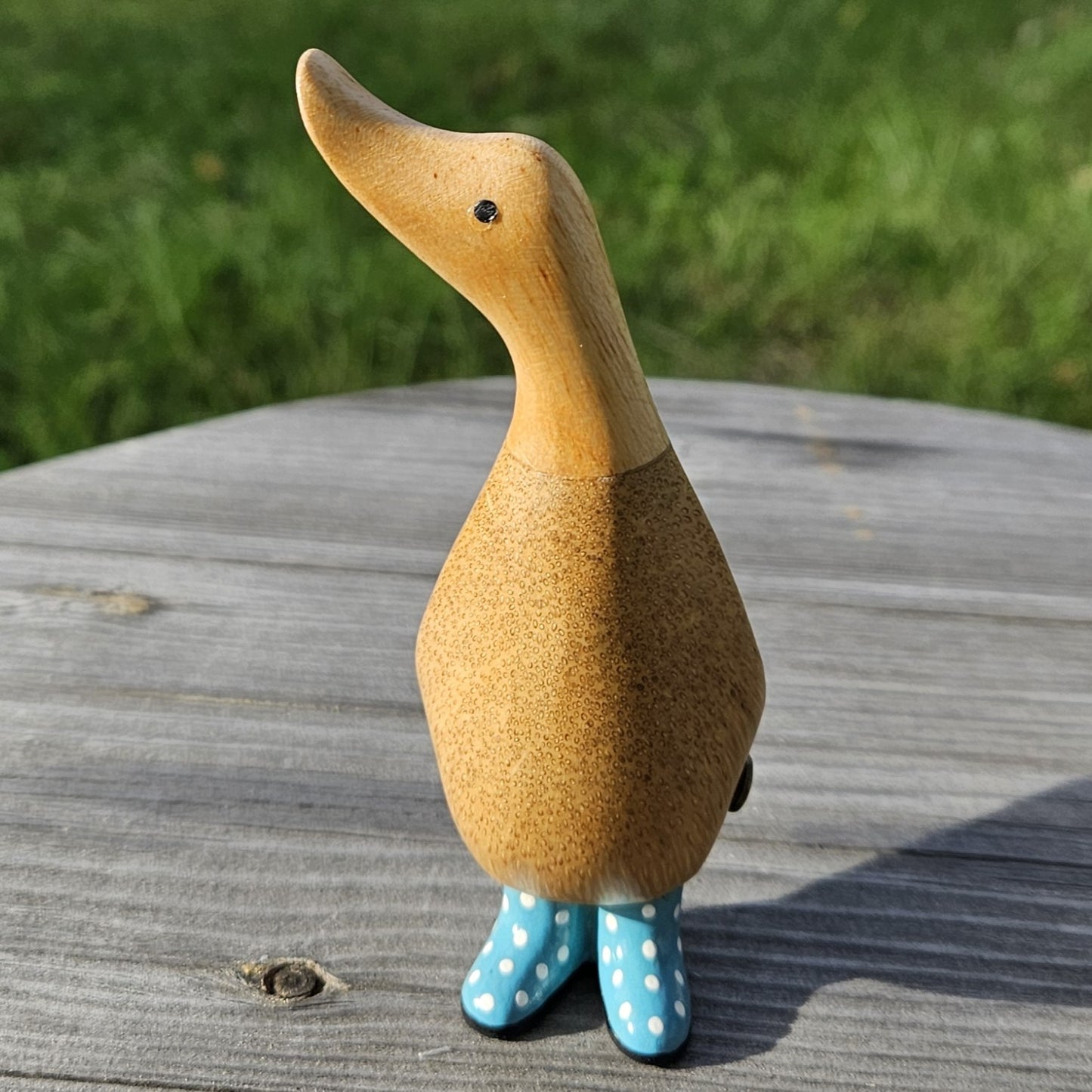 Liten anka i bambu med blå stövlar, tittar åt höger - Naturboden